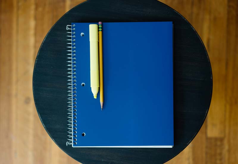 Pencil and highlighter on a closed spiral notebook Image
