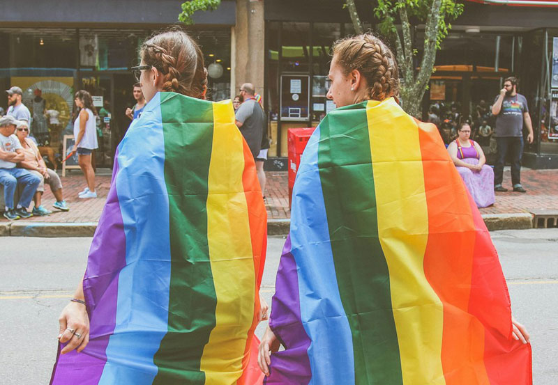 Two Women Wear Rainbow Flags Image