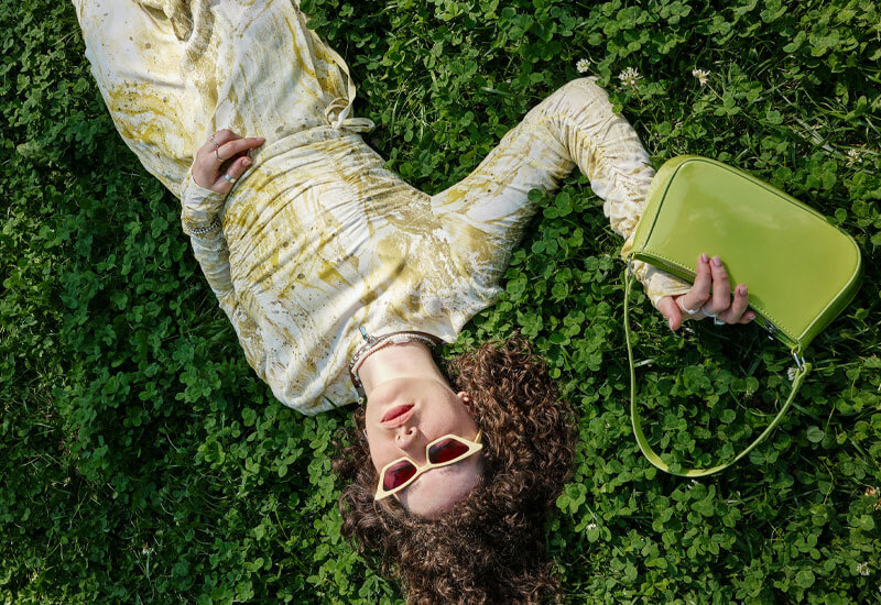 Woman laying on the Ground with a Purse Image