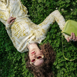 Woman laying on the Ground with a Purse - Image